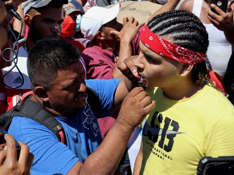 Migrantes cosen sus labios en protesta por no poder viajar a la frontera